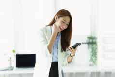肖像成功的亚洲女商人业务老板表达兴奋快乐智能手机移动办公室