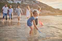 多一代家庭持有手走海滩高加索人家庭孩子们父母爷爷奶奶享受夏天假期孩子们网水
