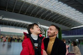 肖像快乐的爸爸沟通儿子等待海关控制离开终端国际机场