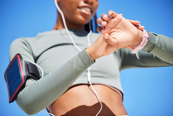适合非洲美国女人检查智能手表时机进步运动女人听音乐手机耳机检查脉冲看锻炼