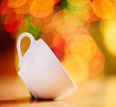 特写镜头杯孤立的色彩鲜艳的散景背景白色茶杯倾斜的一边表格陶器享受温暖的饮料茶咖啡咖啡馆首页