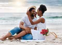 快乐的非洲美国夫妇支出一天海内容的男朋友女朋友盯着眼睛深情地坐着海滩有爱心的丈夫妻子成键海滨