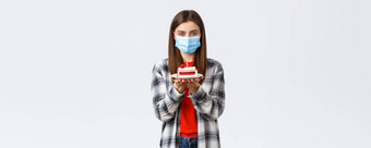 冠状病毒爆发生活方式社会距离假期庆祝活动概念可爱的年轻的女人医疗面具庆祝生日检疫持有生日蛋糕