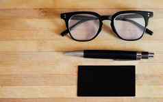 生活平躺拍摄眼镜演出眼镜笔记事本笔记本木表格桌子上明亮的现代企业办公室业务概念设置
