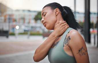 年轻的非洲美国女人苦苦挣扎的脖子受伤锻炼城市美丽的混合比赛女人锻炼持有脖子疼痛苦苦挣扎的抽筋