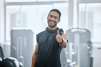 肖像微笑教练健身房显示拇指标志象征亚洲教练支持支持锻炼锻炼健康俱乐部年轻的快乐男人。健身中心例程培训