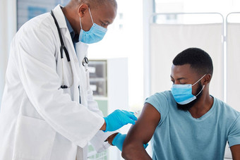 医生注射病人科维德疫苗非洲美国医生持有针填满治愈医疗给病人电晕治愈医生病人穿面具