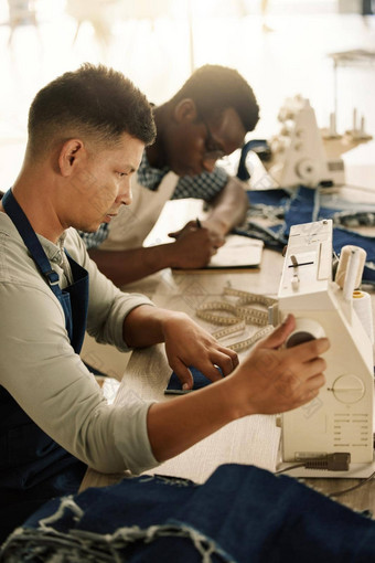 年轻的设计师缝纫机裁缝缝纫机准备好了年轻的商人把刻度盘缝纫机有创意的裁缝缝纫机