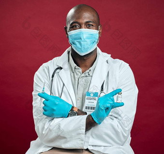 非洲美国科维德医生持有电晕疫苗针穿外科手术脸面具肖像黑色的医生持有药物瓶注射器红色的工作室背景Copyspace