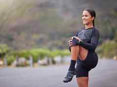 活跃的适合年轻的混合比赛女人伸展运动腿户外锻炼微笑健美的拉美裔运动员准备好了运行早....例程体育物理活动健康的