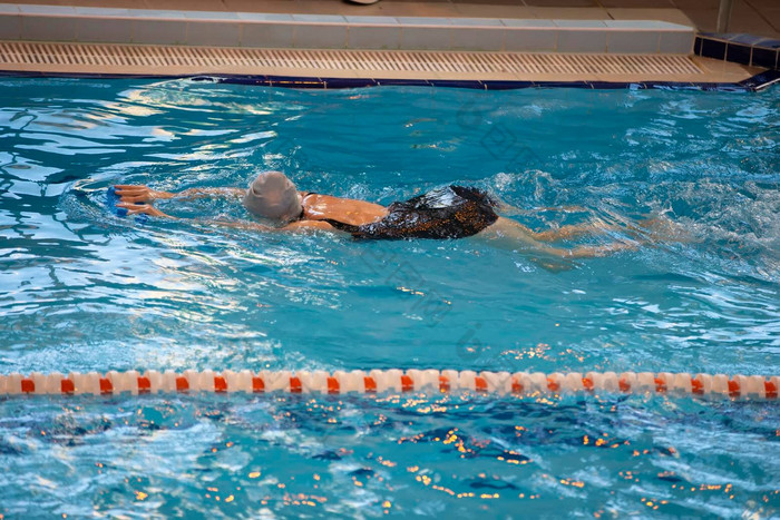 女人游泳黑色的泳衣游泳帽游泳池