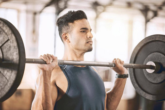 集中健美运动员提升重权重活跃的运动员建筑手臂肌肉重杠铃强大的教练锻炼例程健身房肌肉发达的适合男人。健身房