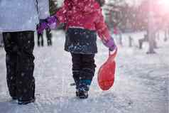 女孩持有红色的雪橇手骑山二次破碎活动孩子们青少年冬天娱乐体育