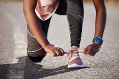 活跃的适合女人系鞋带运动鞋锻炼在户外运动员紧固鞋子准备好了运行慢跑早....准备让人耳目一新有氧运动锻炼