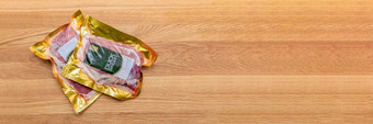 真空包装鸭乳房鸭肉真空塑料包装木切割董事会背景烹饪主题的地方文本