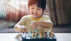 亚洲婴儿玩国际象棋生活房间首页聪明的孩子时尚孩子们天才孩子聪明的游戏棋盘婴儿活动概念