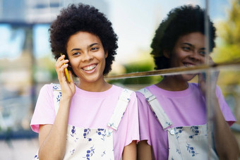快乐的黑色的女人会说话的智能手机建筑