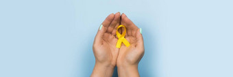 黄色的黄金丝带手女孩蓝色的背景孩子们癌症概念意识月童年癌症一天2月网络横幅