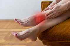 女人持有美丽的健康的长腿按摩胫骨小腿疼痛区域