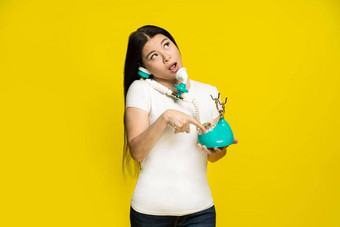 有趣的亚洲女人古董复古的电话手做梦拨号还记得电话数量脸表达式穿白色t恤孤立的黄色的背景