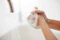 认不出来女人洗手厨房水槽未知的混合比赛女人泡沫覆盖手洗手指掉细菌