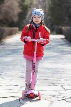 快乐学前教育女孩骑踏板车春天一天公共公园