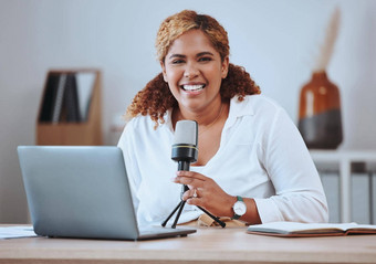 肖像微笑年轻的混合比赛女主持人小无线移动PC播客坐着首页拉美裔女博主设备社会媒体播客