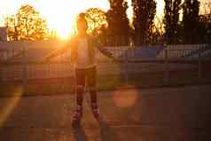 女孩骑辊溜冰鞋公园