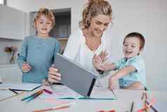 家庭距离学习视频调用学习教学在线快乐妈妈。男孩数字平板电脑在线教育父帮助家庭作业