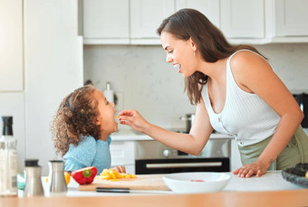 妈妈。喂养孩子蔬菜<strong>烹饪</strong>厨房妈妈告诉女儿开放宽吃蔬菜