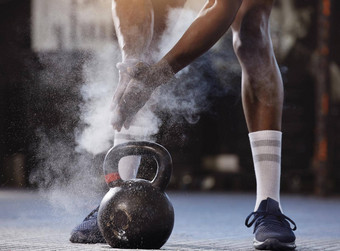 特写镜头未知的非洲美国运动员粉粉笔手提升壶铃健身房强大的适合活跃的黑色的男人。准备好了锻炼举重锻炼例程