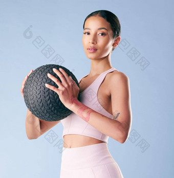 混合比赛健身女人站医学球大满贯球工作室蓝色的背景美丽的年轻的拉美裔女运动员锻炼工作健康健身