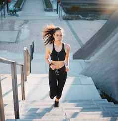 健身水平上升完整的长度拍摄有吸引力的年轻的女运动员锻炼城市