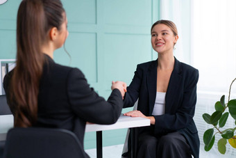 工作面试业务职业生涯放置概念年轻的金发女郎女人握手候选人手坐着前面候选人企业会议工作面试