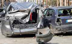 破碎的车交通事故停车很多修复站车身体损害车间在户外出售保险汽车事故街车碰撞城市