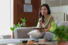 肖像年轻的亚洲女人社会媒体聊天数字平板电脑生活方式购物在线放松沙发