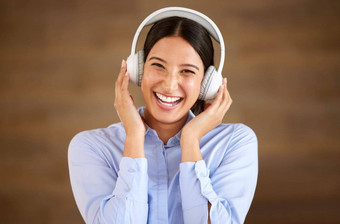 快乐年轻的混合比赛女商人穿无线耳机工作女享受听放松音乐歌曲音频书播客压力救援打破
