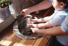 开始洗手拍摄年轻的男孩父亲洗手厨房