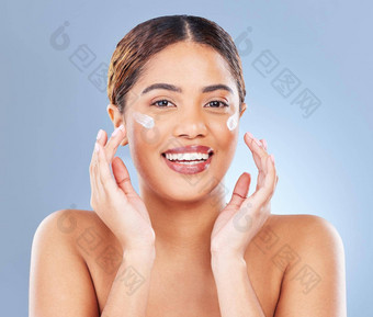 皮爱的产品拍摄年轻的女人应用乳液脸灰色背景