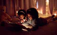 魔法书拍摄可爱的女孩阅读书房间晚上