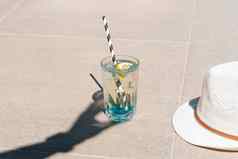 特写镜头拍摄手的影子持有闪闪发光的薄荷柠檬水热带鸡尾酒玻璃站大理石地板上夏天假期假期复制空白空间
