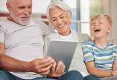 快乐成熟的夫妇成键孙子保姆数字平板电脑视频调用首页爷爷奶奶放松可爱的孙子浏览
