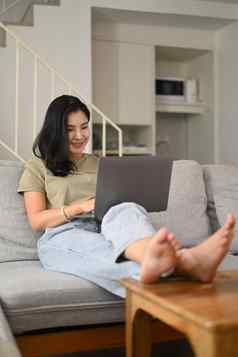 放松年轻的女人看视频冲浪互联网购物在线移动PC电脑生活房间