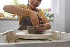 集中亚洲女人使陶瓷能陶工轮活动工艺品爱好概念