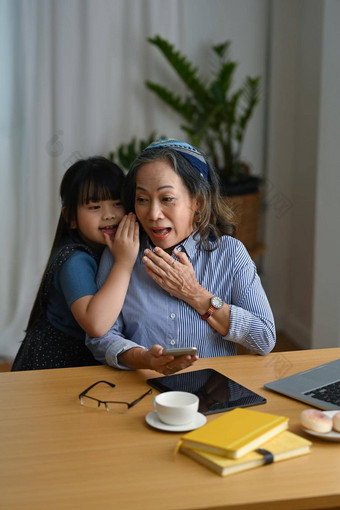 可爱的亚洲孩子窃窃私语高级祖母爱的家庭的关系概念