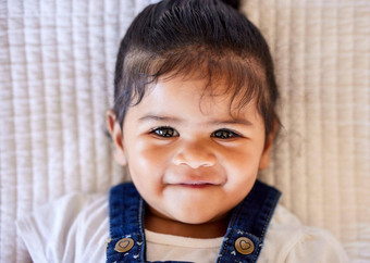 脸可爱的婴儿微笑相机肖像可爱的婴儿女孩说谎床上快乐的
