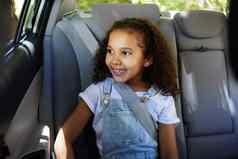 裁剪拍摄可爱的女孩深思熟虑的坐着后座车