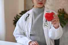 亚洲女医生持有红色的心形状手医疗保健医疗概念
