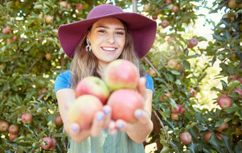 肖像快乐年轻的女人持有新鲜选红色的树可持续发展的果园农田阳光明媚的一天农民收获多汁的有营养的有机水果季节准备好了吃