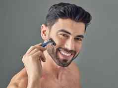 胡子梳理工具包拍摄英俊的年轻的男人。剃须胡子站灰色背景